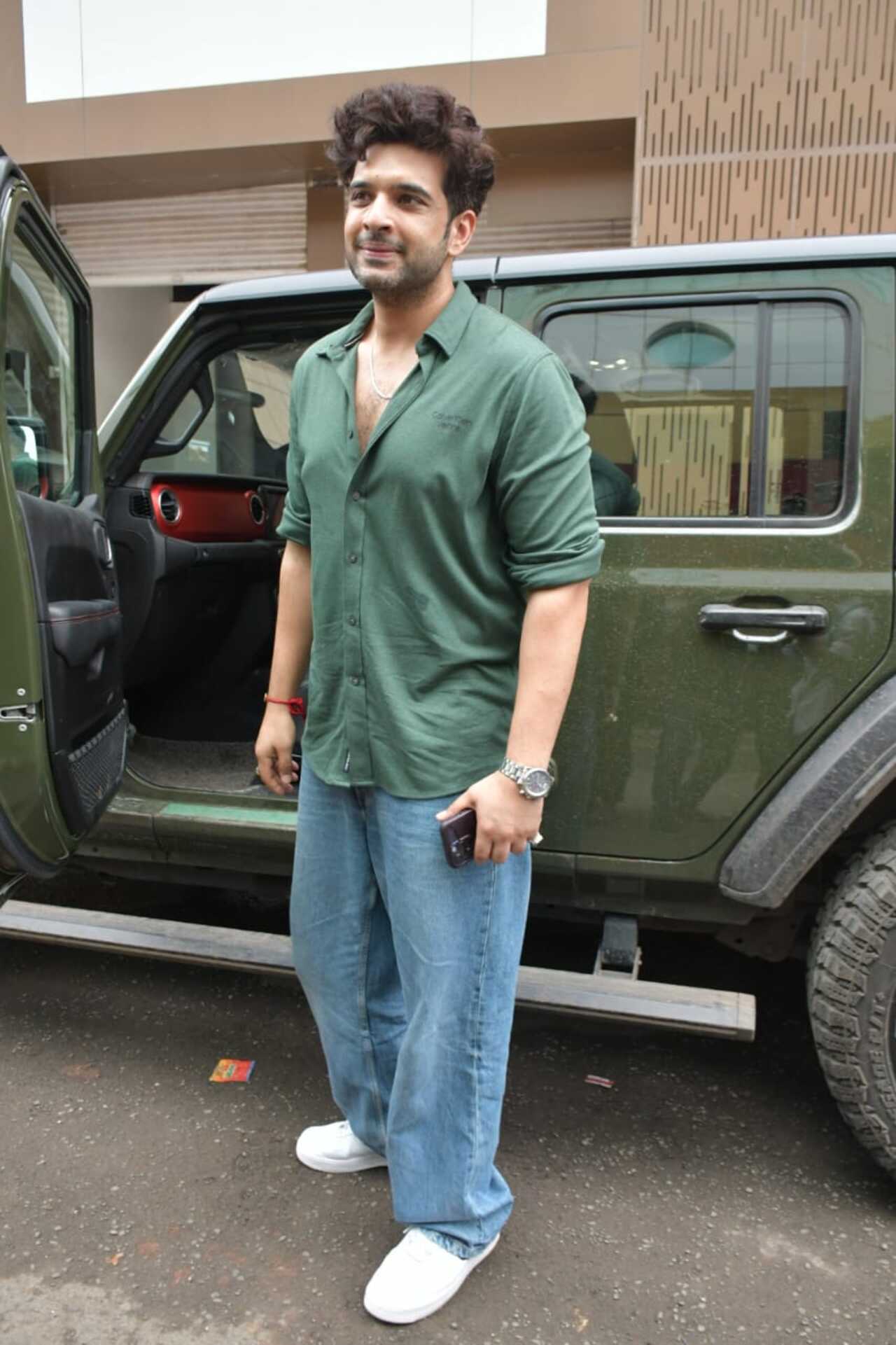 Karan was dressed in a green shirt and baggy jeans